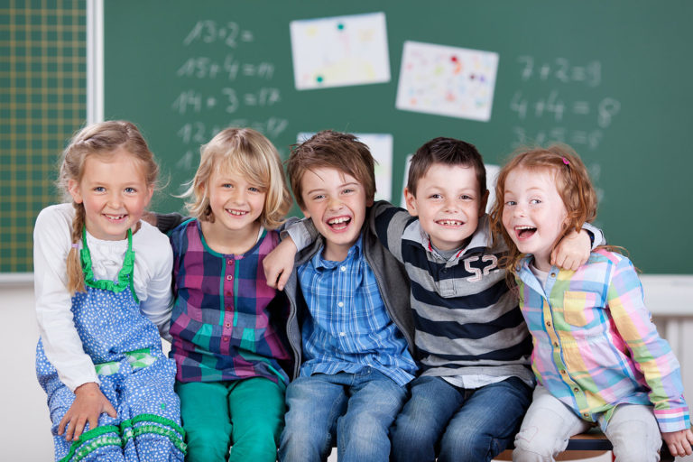 Five school nursery children smile during picture day