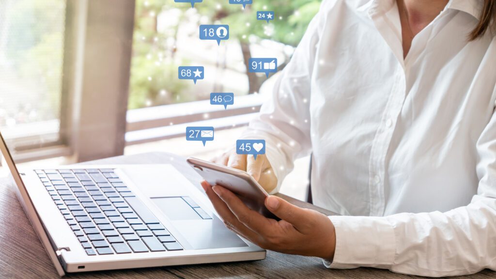 Woman Using smart phone emitting holographic image of social media