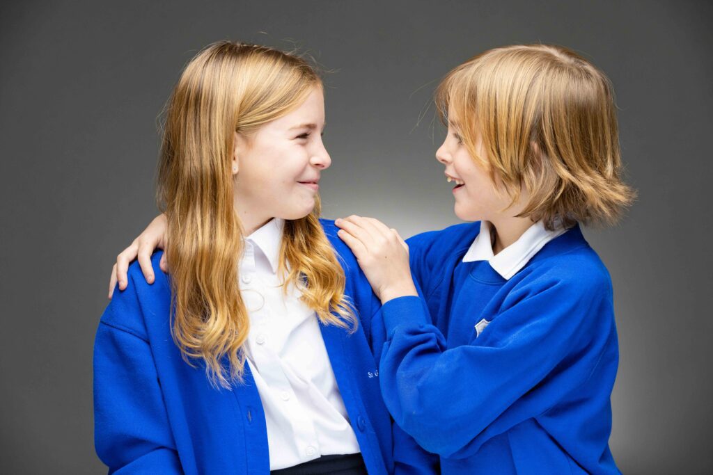two schoolchildren looking at each other smiling