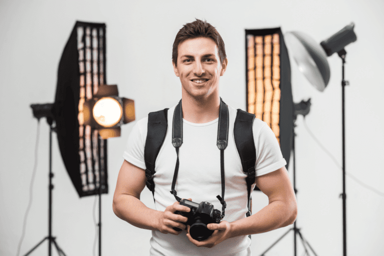 A photographer holds a camera in front of lighting equipment