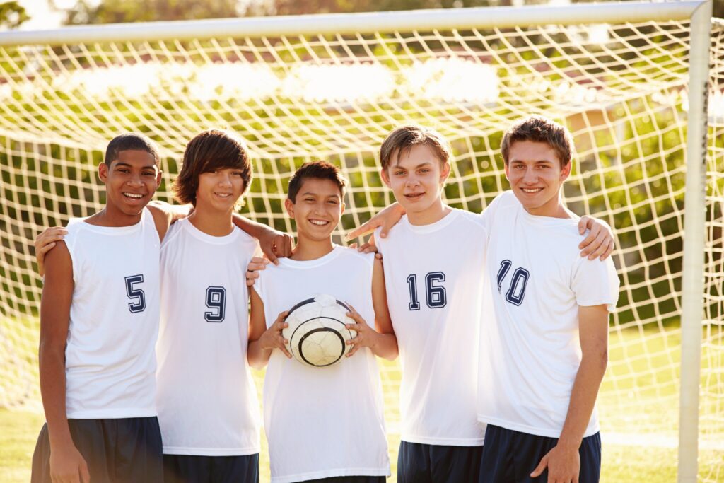 A boys' football team poses in front of the goal