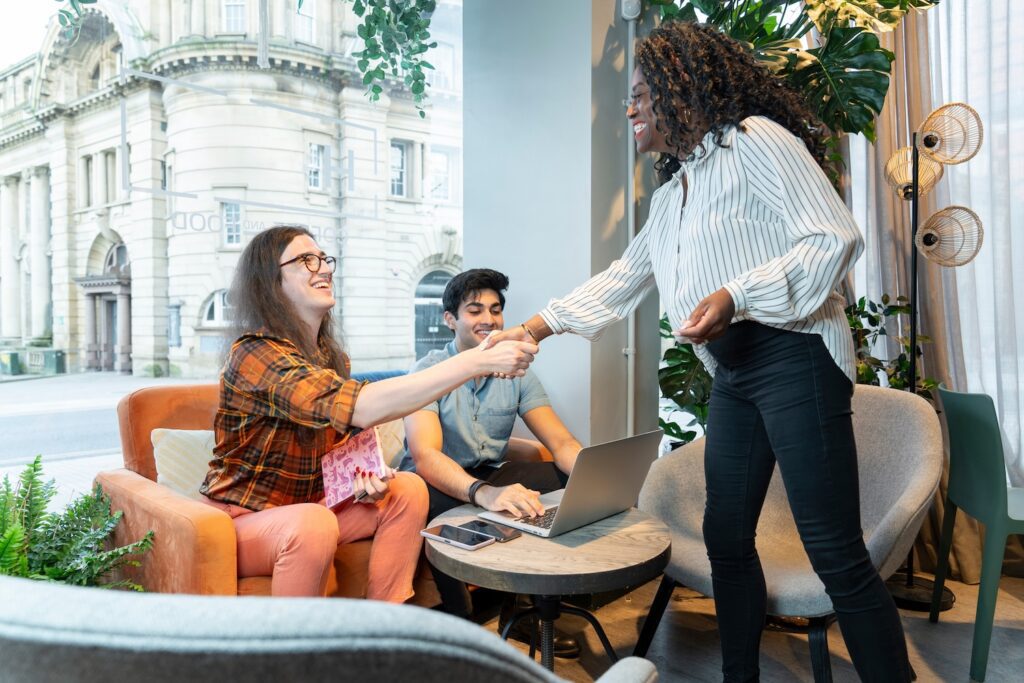 young people shaking hands in a cafe