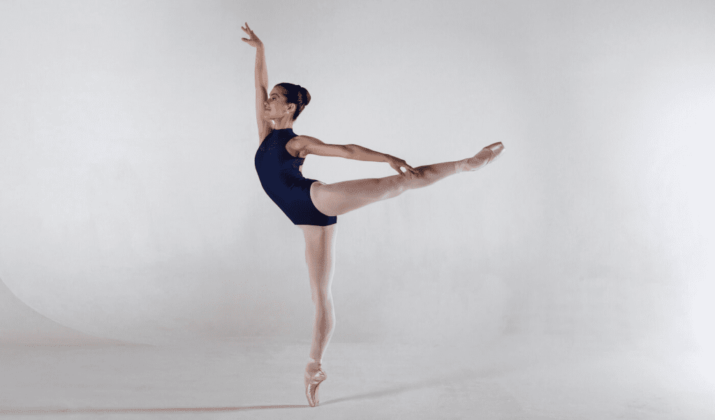ballerina in black leotard doing arabesque hold